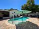 Backyard featuring a pristine in-ground pool surrounded by a brick paver deck and serene landscaping at 7215 121St Ter, Largo, FL 33773