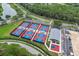 Bird's-eye view of new pickleball courts, a surrounding neighborhood, and a nearby lake at 7305 Sugarbush, Spring Hill, FL 34606