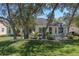 Manicured backyard with mature trees, landscaping, and paver patio with seating at 7305 Sugarbush, Spring Hill, FL 34606