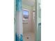 This bathroom features a tiled shower with window and a decorative blue curtain at 7305 Sugarbush, Spring Hill, FL 34606