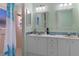 Beautiful bathroom featuring double sinks, a framed vanity mirror, and a tiled shower at 7305 Sugarbush, Spring Hill, FL 34606
