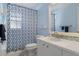 Bright bathroom featuring a stylish vanity, modern toilet, and a shower with blue patterned shower curtain at 7305 Sugarbush, Spring Hill, FL 34606