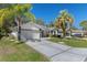 Charming single-story home features a well-manicured lawn, attractive landscaping, and a patterned concrete driveway at 7305 Sugarbush, Spring Hill, FL 34606