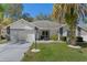 Charming single-story home boasts a well-manicured lawn, beautiful landscaping, and a welcoming facade at 7305 Sugarbush, Spring Hill, FL 34606