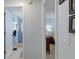 Hallway view to bathroom with blue shower curtain and bedroom with a bed, dresser and night stand at 7305 Sugarbush, Spring Hill, FL 34606