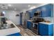 Kitchen with blue cabinets and modern appliances, complemented by tiled backsplash and ample counter space at 7305 Sugarbush, Spring Hill, FL 34606