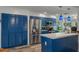 Bright kitchen boasts blue cabinets, stainless steel appliances, and ample counter space for cooking at 7305 Sugarbush, Spring Hill, FL 34606