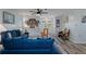 Inviting living room with blue couch, ceiling fan, and decorative wall art providing a cozy atmosphere at 7305 Sugarbush, Spring Hill, FL 34606