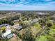 An aerial view shows the home in a residential neighborhood and a pond at 8367 Apple Orchard Rd, Spring Hill, FL 34608