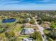 A serene aerial view of a home near a lake, nestled within a lush, wooded neighborhood at 8367 Apple Orchard Rd, Spring Hill, FL 34608
