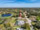 A serene aerial view of a home near a lake, nestled within a lush, wooded neighborhood at 8367 Apple Orchard Rd, Spring Hill, FL 34608