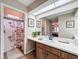 Bright bathroom featuring vanity with marble countertop, framed art, and a floral shower curtain at 8367 Apple Orchard Rd, Spring Hill, FL 34608
