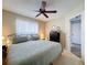 Comfortable bedroom featuring ceiling fan, a dark dresser, and a large window with sheer curtains at 8367 Apple Orchard Rd, Spring Hill, FL 34608