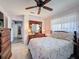 Comfortable bedroom features a queen size bed, wooden dresser, ceiling fan, and neutral walls at 8367 Apple Orchard Rd, Spring Hill, FL 34608