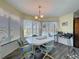 Bright dining area features a modern chandelier, seating for six, and large windows with views of the pool at 8367 Apple Orchard Rd, Spring Hill, FL 34608