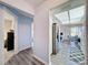 Hallway leads into the kitchen and dining nook, featuring stainless steel appliances, and light gray wood floors at 8367 Apple Orchard Rd, Spring Hill, FL 34608