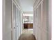 Hallway with closet doors leading into the kitchen with wood flooring and wooden cabinets at 8367 Apple Orchard Rd, Spring Hill, FL 34608