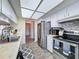 Galley kitchen with white cabinets, modern appliances, and tiled backsplash at 8367 Apple Orchard Rd, Spring Hill, FL 34608