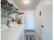 The spacious laundry room featuring a washer, dryer, shelving, and a refrigerator at 8367 Apple Orchard Rd, Spring Hill, FL 34608