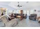 Spacious living room with carpeting, vaulted ceilings, and fan; open to the breakfast bar and kitchen at 8367 Apple Orchard Rd, Spring Hill, FL 34608