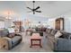 Spacious living room with carpeting, vaulted ceilings, and fan; open to the breakfast bar and kitchen at 8367 Apple Orchard Rd, Spring Hill, FL 34608