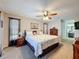 Spacious bedroom with ceiling fan, nightstands, large bed, and decor at 8367 Apple Orchard Rd, Spring Hill, FL 34608
