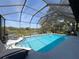 Sparkling pool under a screened enclosure with an outdoor view at 8367 Apple Orchard Rd, Spring Hill, FL 34608