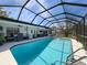 Screened in pool in backyard patio with comfortable lounge chairs at 8367 Apple Orchard Rd, Spring Hill, FL 34608