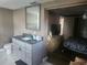 Bathroom view includes a granite vanity, gray cabinetry, and a view into an adjacent bedroom at 8501 Hunting Saddle Dr, Hudson, FL 34667