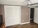 Bedroom with a light ceiling fan and sliding closet doors, neutral wall and wood-look flooring at 8501 Hunting Saddle Dr, Hudson, FL 34667