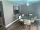 Bright dining room with a modern glass table and six chairs, and wood-look floors at 8501 Hunting Saddle Dr, Hudson, FL 34667