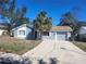 Charming single-story home with blue exterior, well-maintained lawn, and a spacious driveway at 8501 Hunting Saddle Dr, Hudson, FL 34667