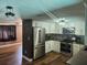 Modern kitchen with stainless steel appliances, white cabinets, and wood-look flooring open to the living area at 8501 Hunting Saddle Dr, Hudson, FL 34667