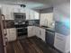 Modern kitchen with stainless steel appliances, white cabinetry, and dark countertops at 8501 Hunting Saddle Dr, Hudson, FL 34667