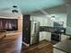 Updated kitchen with stainless steel appliances, white cabinets, and wood-look flooring open to the living area at 8501 Hunting Saddle Dr, Hudson, FL 34667