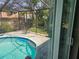 Relaxing screened-in pool area with a clear view of the lush backyard, perfect for summer enjoyment at 8501 Hunting Saddle Dr, Hudson, FL 34667