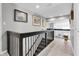 Upstairs hallway features wooden floors, black railings, and bright neutral walls at 9020 Sharon Dr, New Port Richey, FL 34654