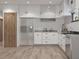 Bright kitchen featuring white cabinets, stainless steel appliances, and light hardwood flooring at 9024 Waterbird Way, Brooksville, FL 34613