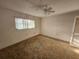 Bedroom with ceiling fan, natural light, and neutral walls complemented by carpet flooring at 10803 Hachita Dr, Port Richey, FL 34668
