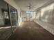 Bright sunroom with a ceiling fan, sliding glass door, windows, and neutral carpet at 10803 Hachita Dr, Port Richey, FL 34668