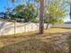 Fenced backyard with a tree, foliage, and a bright sunny sky overhead at 11085 Maderia St, Spring Hill, FL 34609