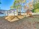 View of the fenced backyard with a play set, shed, and a covered patio area at 11085 Maderia St, Spring Hill, FL 34609