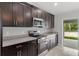 Close up of the kitchen featuring stainless steel appliances, dark cabinets and granite countertops at 11192 Kodiak Wren Rd, Weeki Wachee, FL 34614