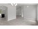 Open-concept living area showcases gray tile flooring, arched doorway, and modern lighting fixtures at 11192 Kodiak Wren Rd, Weeki Wachee, FL 34614