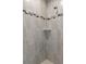 Modern shower featuring light-colored tile, a shower niche, and a shower head at 11192 Kodiak Wren Rd, Weeki Wachee, FL 34614