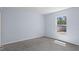 An airy bedroom featuring light blue walls, plush gray carpeting, and a window that lets in natural light at 11220 Sandpiper Ave, Weeki Wachee, FL 34614