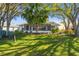 Inviting backyard with a screened lanai, mature trees, and lush greenery, offering a private outdoor retreat at 11231 Sun Tree Rd, Hudson, FL 34667