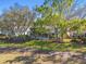 Backyard with a screened lanai and mature trees, offering a private outdoor retreat at 11231 Sun Tree Rd, Hudson, FL 34667