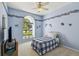 Charming bedroom with blue walls, decorative border, ceiling fan, and a large window at 11231 Sun Tree Rd, Hudson, FL 34667