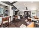 Large dining area with hardwood floors, neutral paint, multiple tables and chairs, a bar area and a ceiling fan at 11231 Sun Tree Rd, Hudson, FL 34667